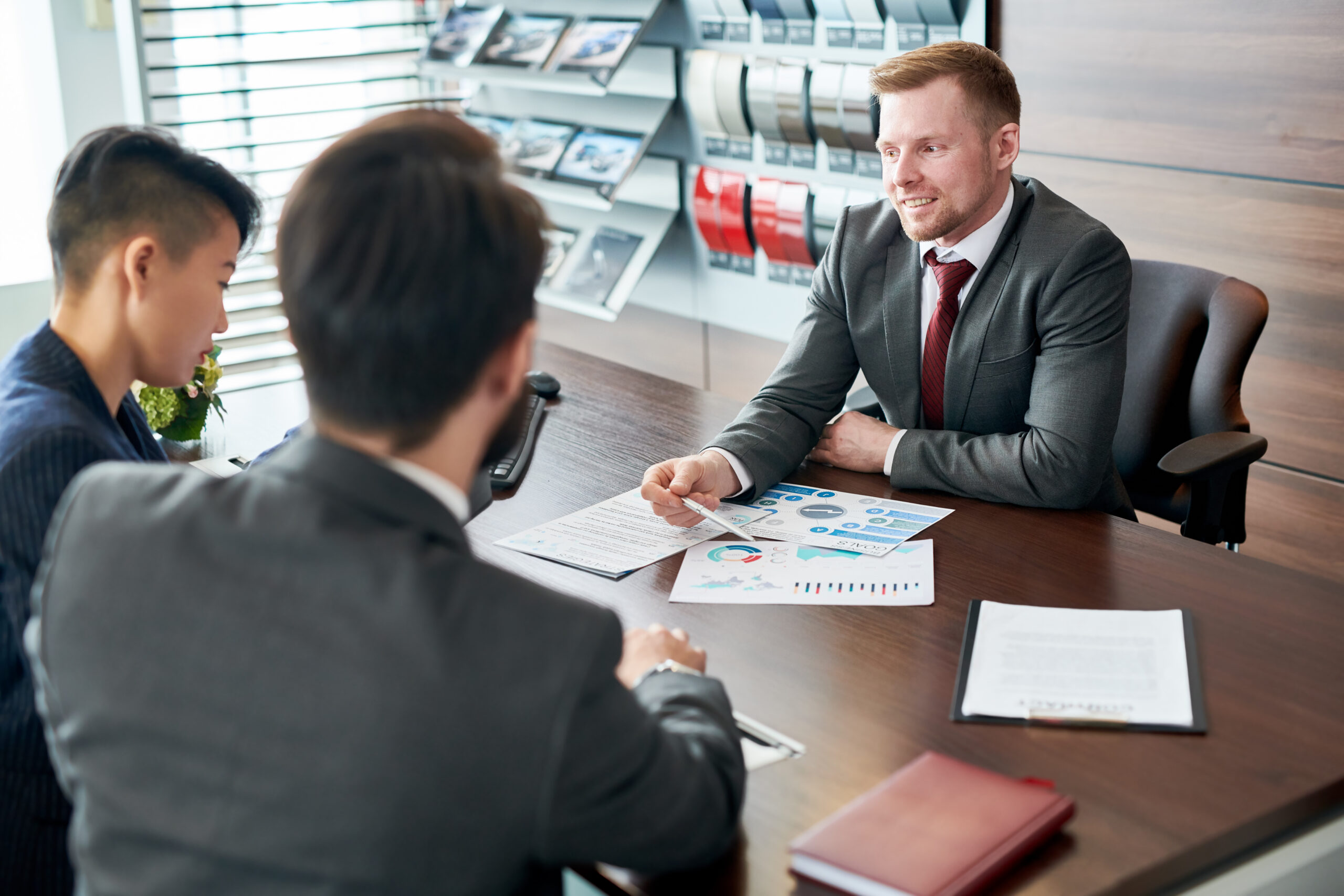 Male leader discussing financial report together with his colleagues at the table